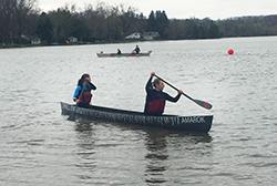 Two students paddle in a concrete canoe