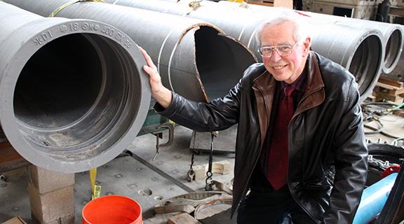 Tom O'Rourke in bovay lab in front of large pipes