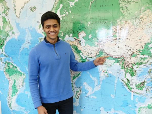 Saurav Sharma standing in front of a map