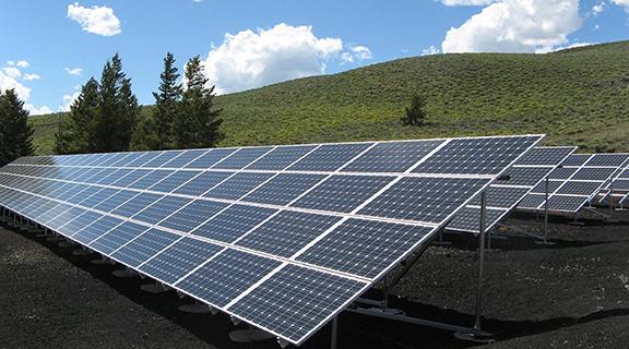 image of solar power panels in a field 
