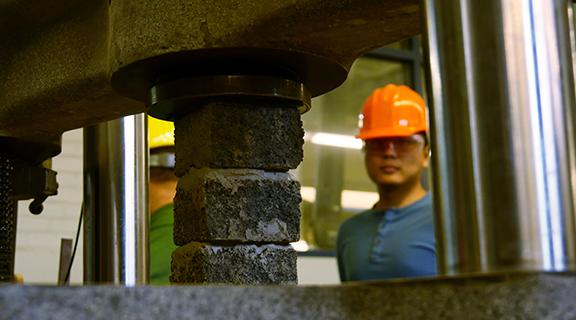 A student in the Bovay lab observes a load testing experiment with cement bricks