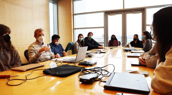 students discussing around a conference room table