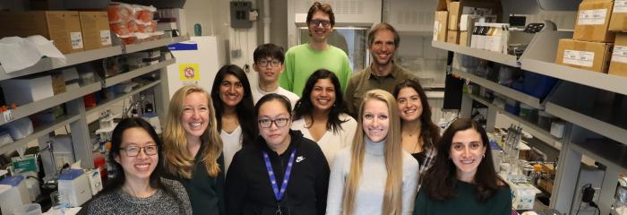 students and faculty member smiling standing in lab for group photo