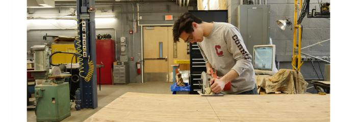 Student using saw in testing space.